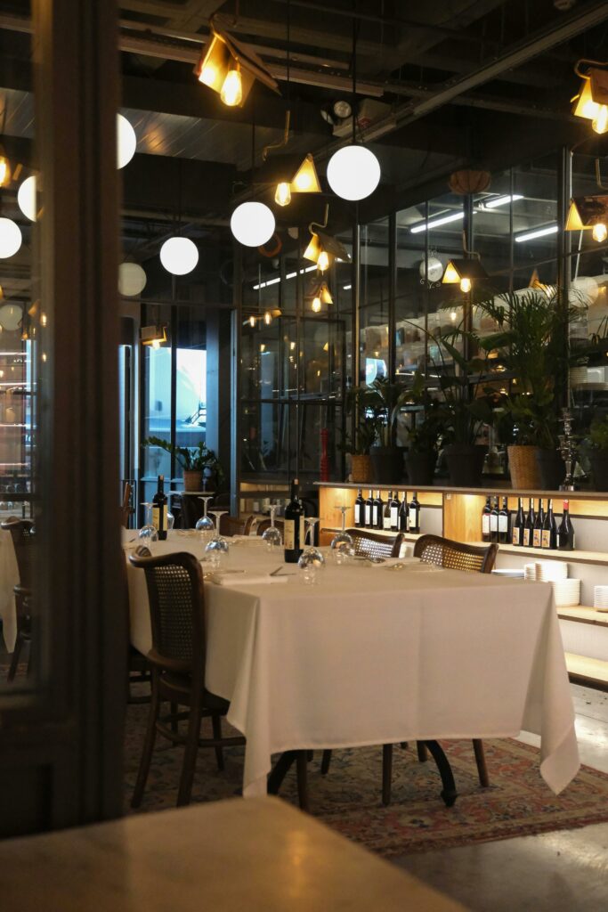 Cozy restaurant interior with elegant lighting and set tables for dining.